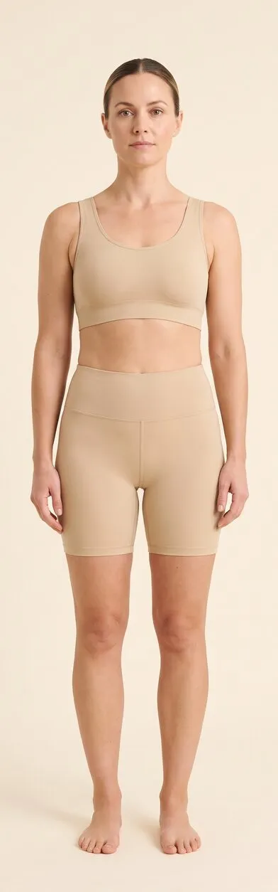 Below the neck. Full-length front-facing photograph of a woman standing in plain activewear, used as a reference plate for the body areas the treatment reaches. Marked areas: 3 chest, 4 shoulders, 5 arms and hands, 6 legs.